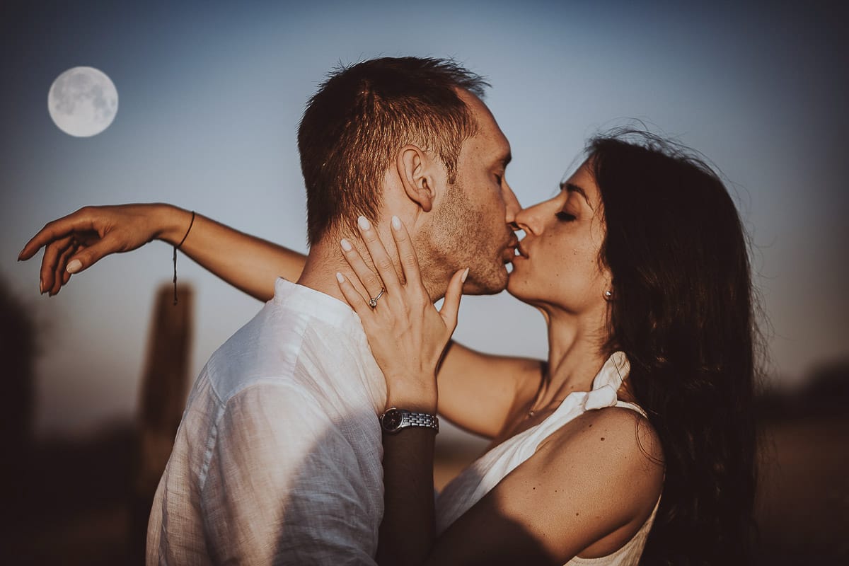 Prewedding romantico e da sogno al tramonto in Monferrato. Ritratto ravvicinato di Valeria e Omar che si baciano con la luna piena.