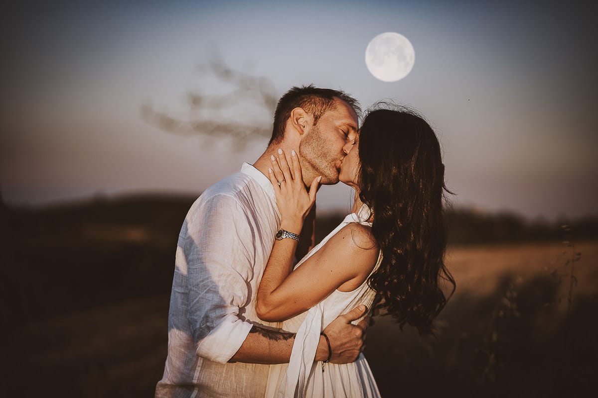 Prewedding romantico e da sogno al tramonto in Monferrato. Ritratto ravvicinato di Valeria e Omar che si baciano con la luna piena.
