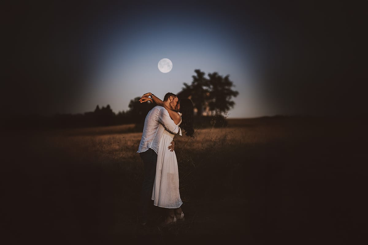 Prewedding romantico e da sogno al tramonto in Monferrato. Ritratto ravvicinato di Valeria e Omar che si baciano con la luna piena.