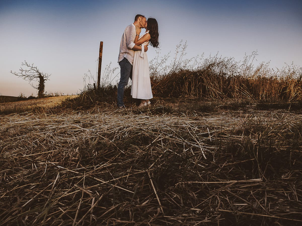 Prewedding romantico e da sogno al tramonto in Monferrato. Ritratto ravvicinato di Valeria e Omar che si baciano con la luna piena. Foto ripresa dal drone posto sul terreno