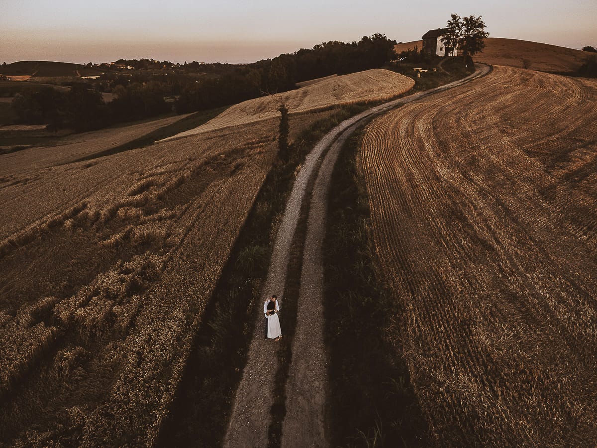 Prewedding romantico e da sogno al tramonto in Monferrato. Omar fa fare una piroetta a Valeria. Foto ripresa dal drone con il panorama e la luna piena.