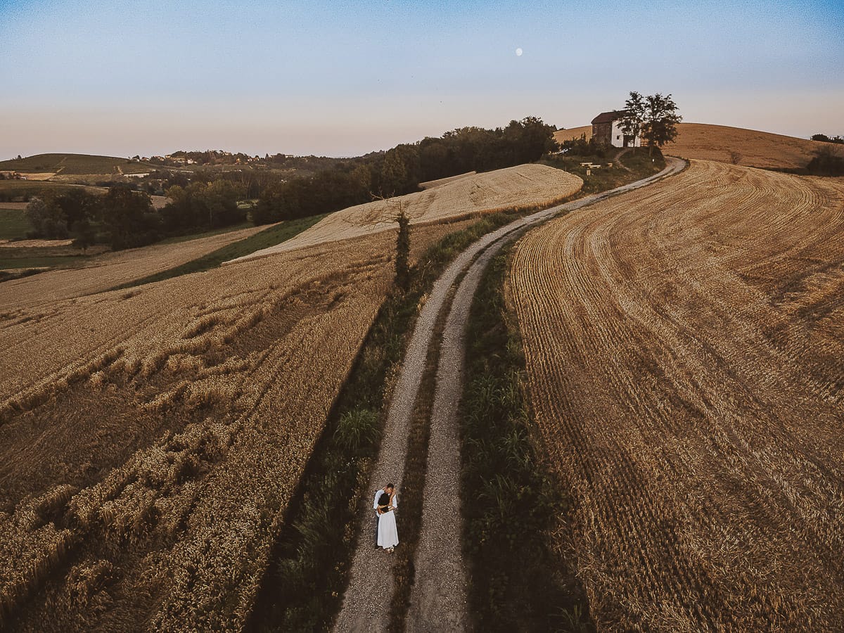 Prewedding romantico e da sogno al tramonto in Monferrato. Omar fa fare una piroetta a Valeria. Foto ripresa dal drone con il panorama e la luna piena.