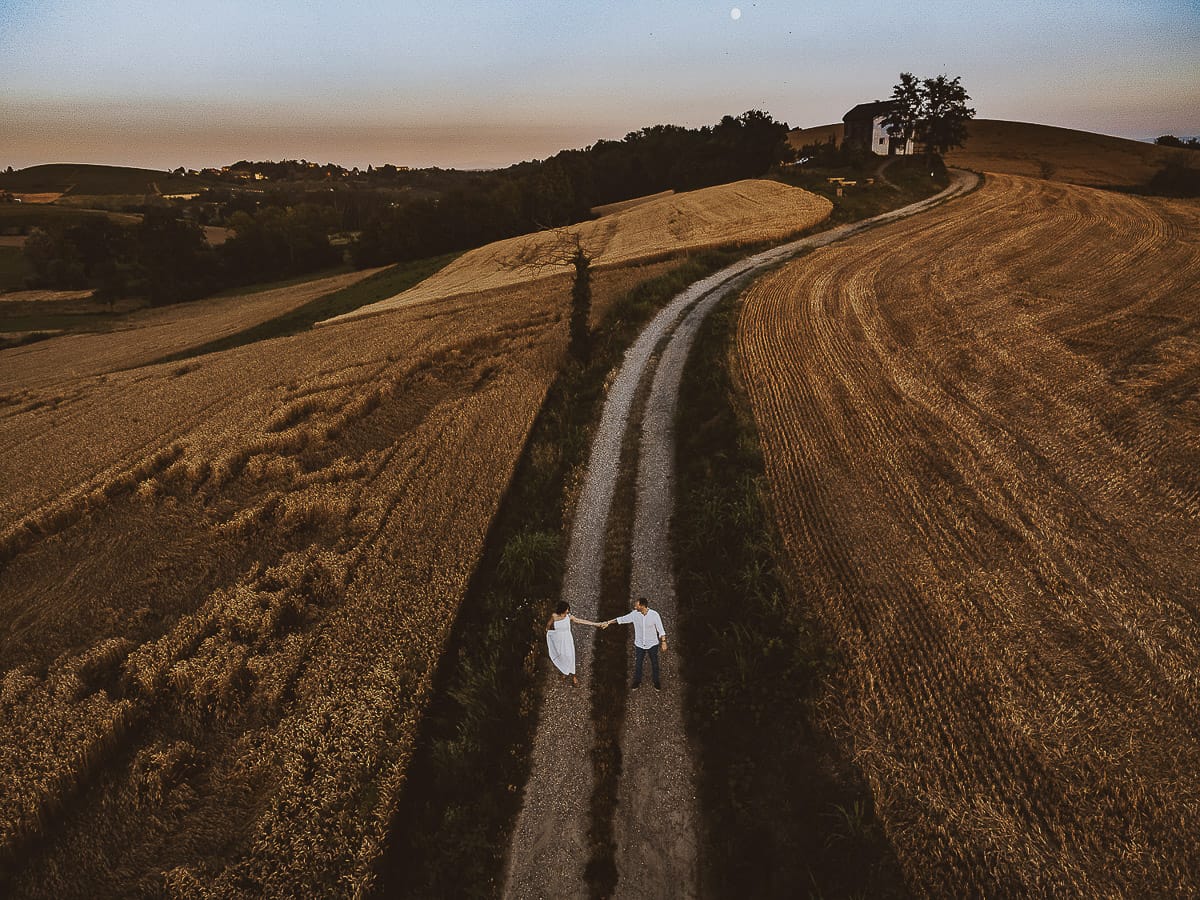 Prewedding romantico e da sogno al tramonto in Monferrato. Omar fa fare una piroetta a Valeria. Foto ripresa dal drone con il panorama e la luna piena.