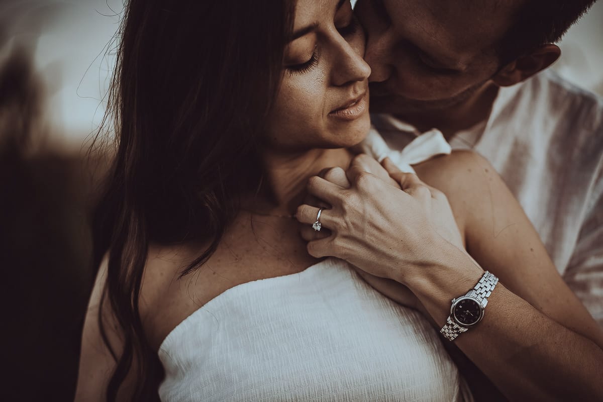 Prewedding romantico e da sogno al tramonto in Monferrato. Ritratto intenso e ravvicinato di Valeria e Omar. Dettaglio sulla mano di Valeria con l'anello di fidanzamento..