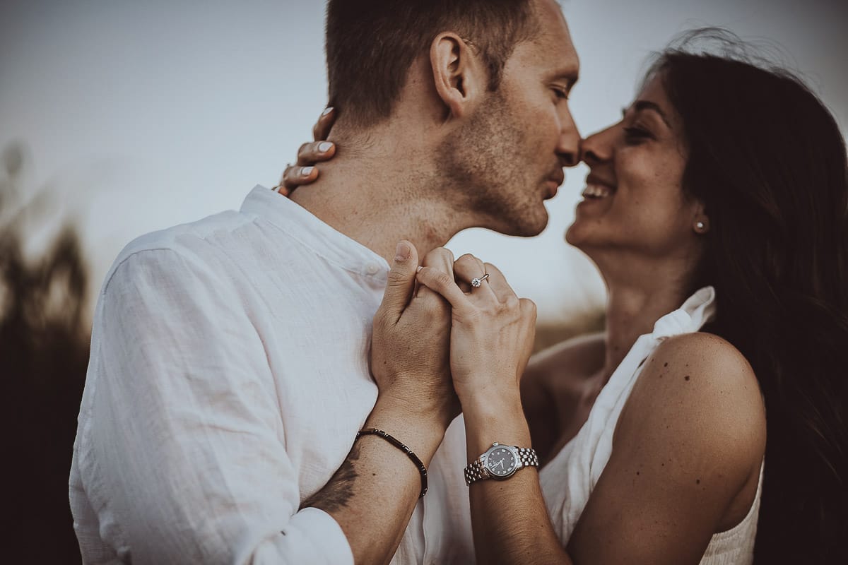 Prewedding romantico e da sogno al tramonto in Monferrato. Ritratto intenso e ravvicinato di Valeria e Omar. Dettaglio sulla mano di Valeria con l'anello di fidanzamento..