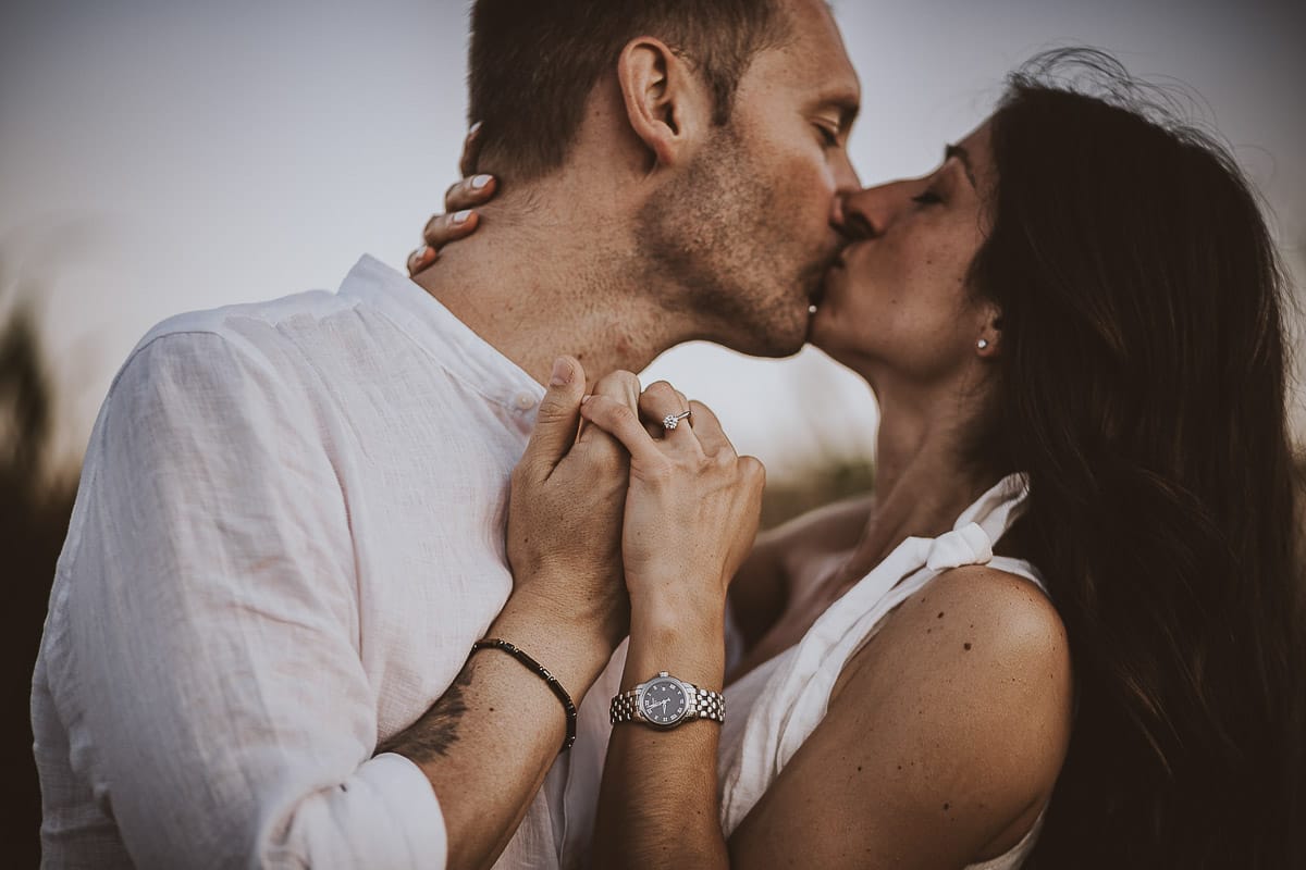 Prewedding romantico e da sogno al tramonto in Monferrato. Ritratto intenso e ravvicinato di Valeria e Omar. Dettaglio sulla mano di Valeria con l'anello di fidanzamento..