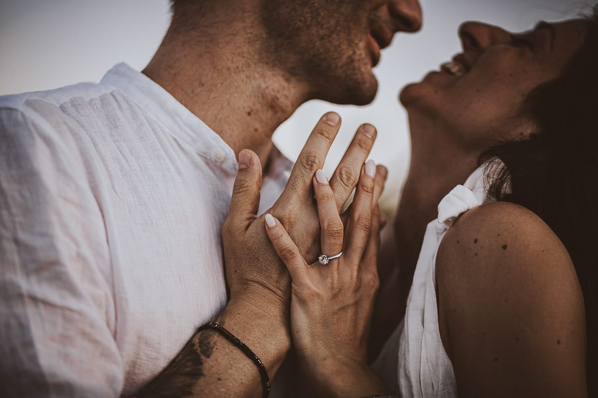 Prewedding romantico e da sogno al tramonto in Monferrato. Ritratto intenso e ravvicinato di Valeria e Omar. Dettaglio sulla mano di Valeria con l'anello di fidanzamento..