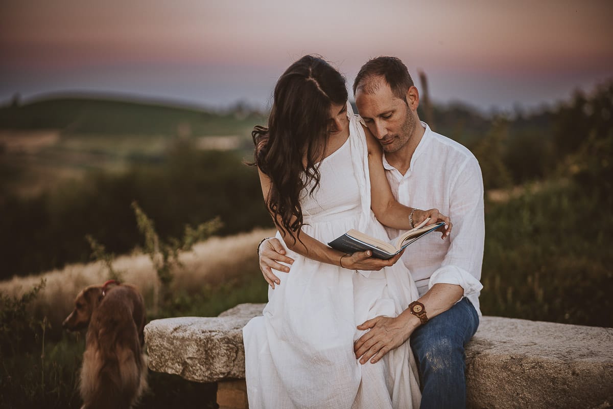 Prewedding romantico e da sogno al tramonto in Monferrato. Valeria e Omar sono seduti su di una panchina e leggono un libro.