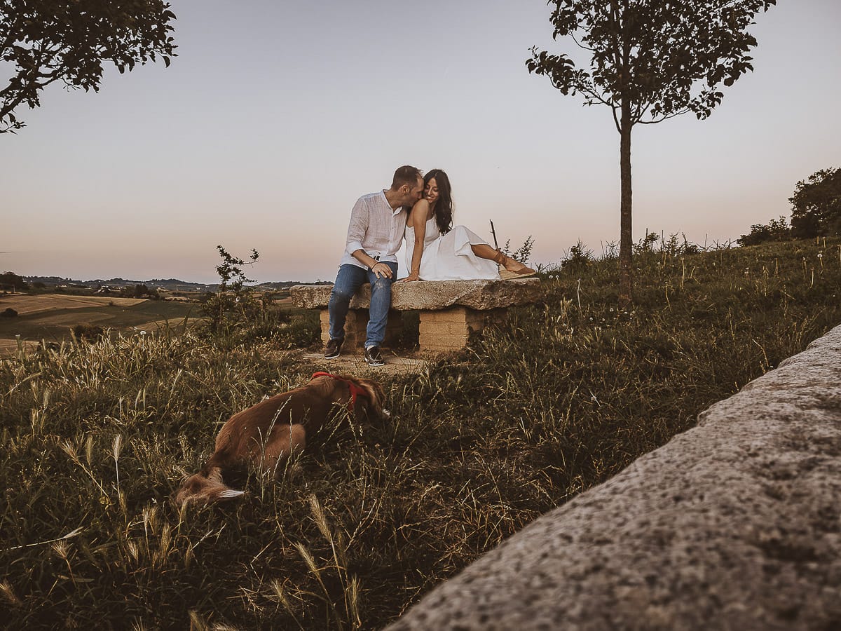 Prewedding romantico e da sogno al tramonto in Monferrato. Valeria e Omar seduti su di una panchina di pietra. Foto ripresa dal drone posto sul terreno.