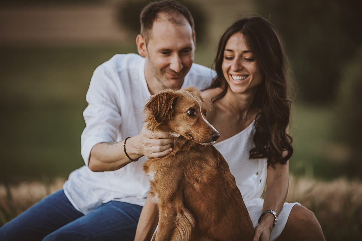 Prewedding romantico e da sogno al tramonto in Monferrato. Valeria e Omar seduti su di una panchina di pietra insieme alla cagnolina Nadine.