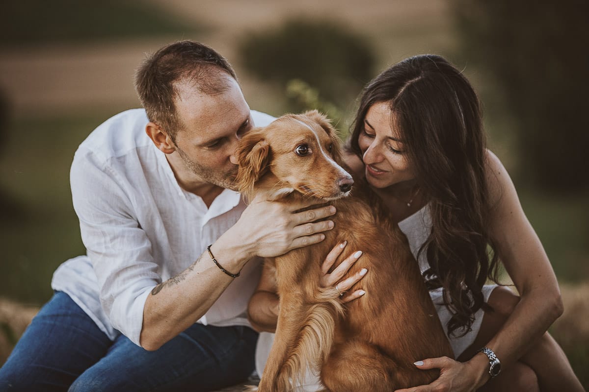 Prewedding romantico e da sogno al tramonto in Monferrato. Valeria e Omar seduti su di una panchina di pietra insieme alla cagnolina Nadine.