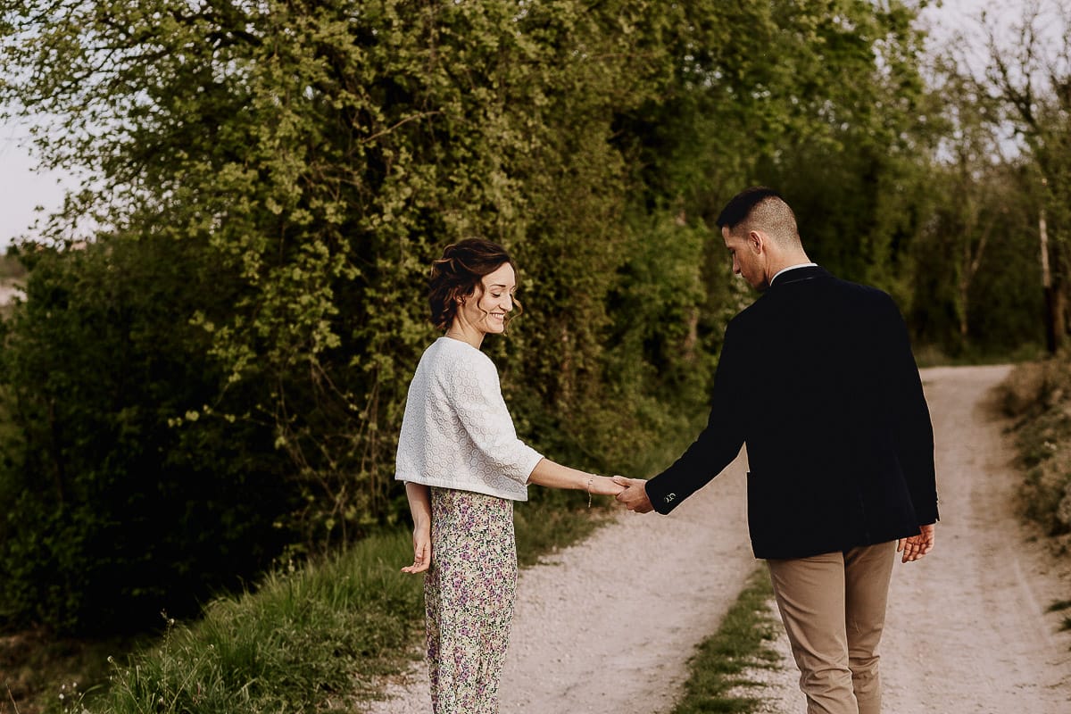 Prewedding primaverile in collina a Mombello di Torino di Federica e Mattia. La coppia cammina tenendosi per mano.