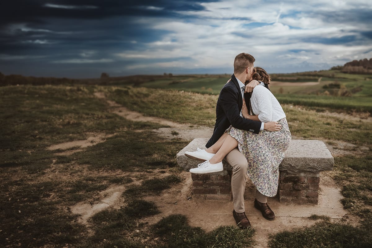 Prewedding primaverile in collina a Mombello di Torino di Federica e Mattia. La coppia è seduta sulla panchina di pietra e si abbraccia