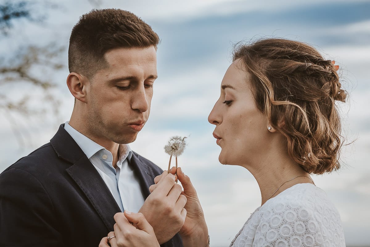Prewedding primaverile in collina a Mombello di Torino di Federica e Mattia. Federica e mattia soffiano un soffione