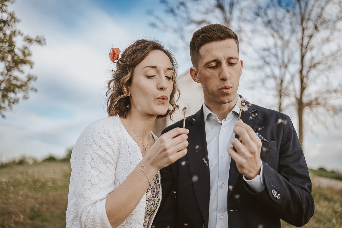 Prewedding primaverile in collina a Mombello di Torino di Federica e Mattia. Federica e mattia soffiano un soffione
