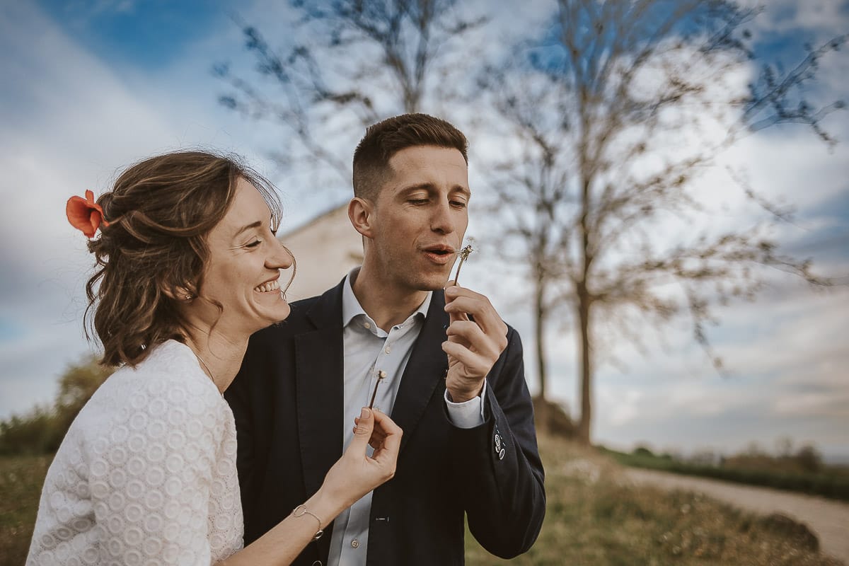 Prewedding primaverile in collina a Mombello di Torino di Federica e Mattia. Federica e mattia soffiano un soffione