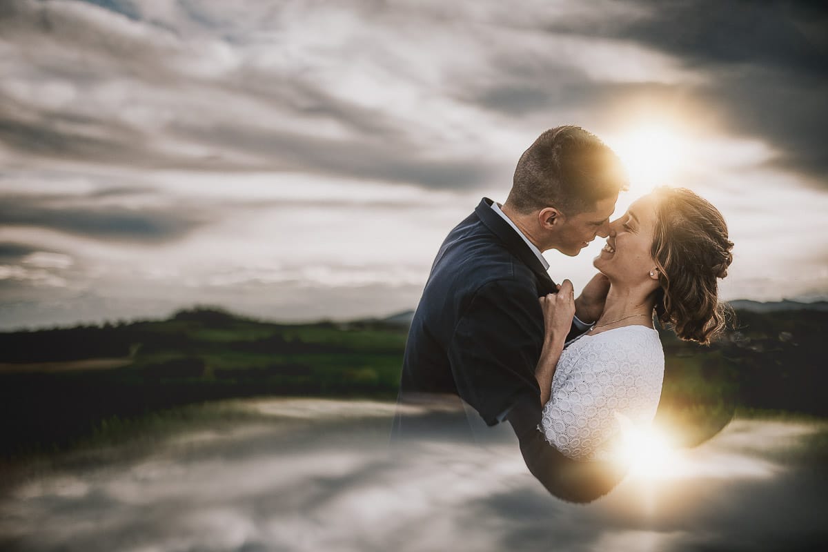 Prewedding primaverile in collina a Mombello di Torino di Federica e Mattia. Ritratto controluce con il sole tra di loro che sta tramontando fra le nuvole- Riflessione con uno specchio.