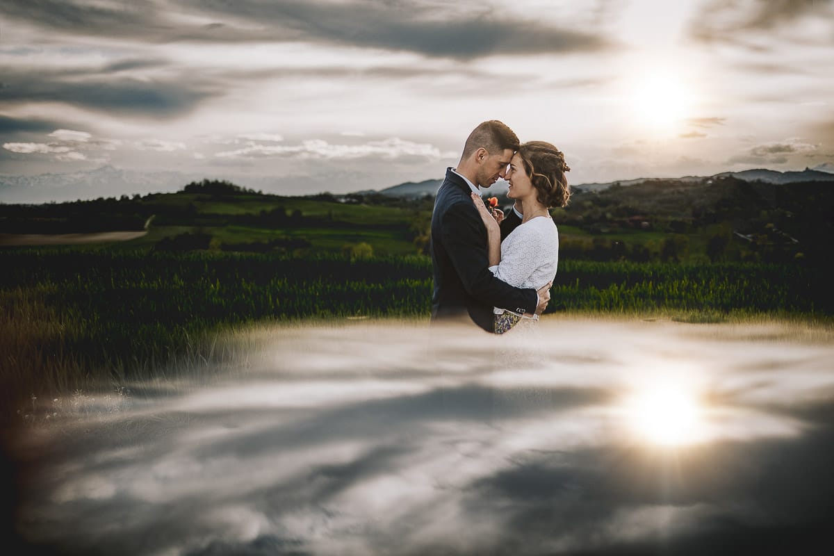Prewedding primaverile in collina a Mombello di Torino di Federica e Mattia. Ritratto controluce con il sole tra di loro che sta tramontando fra le nuvole- Riflessione con uno specchio.