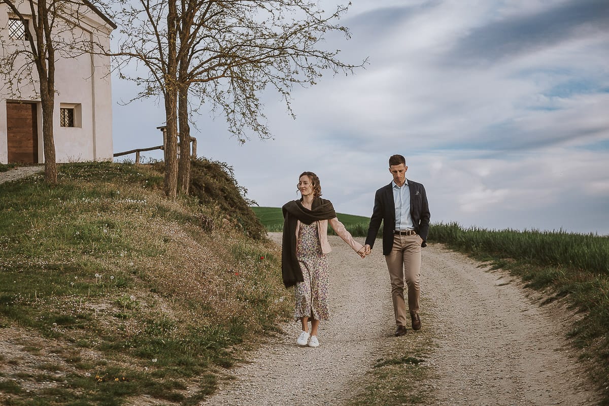 Prewedding primaverile in collina a Mombello di Torino di Federica e Mattia. La coppia cammina tenendosi per mano.