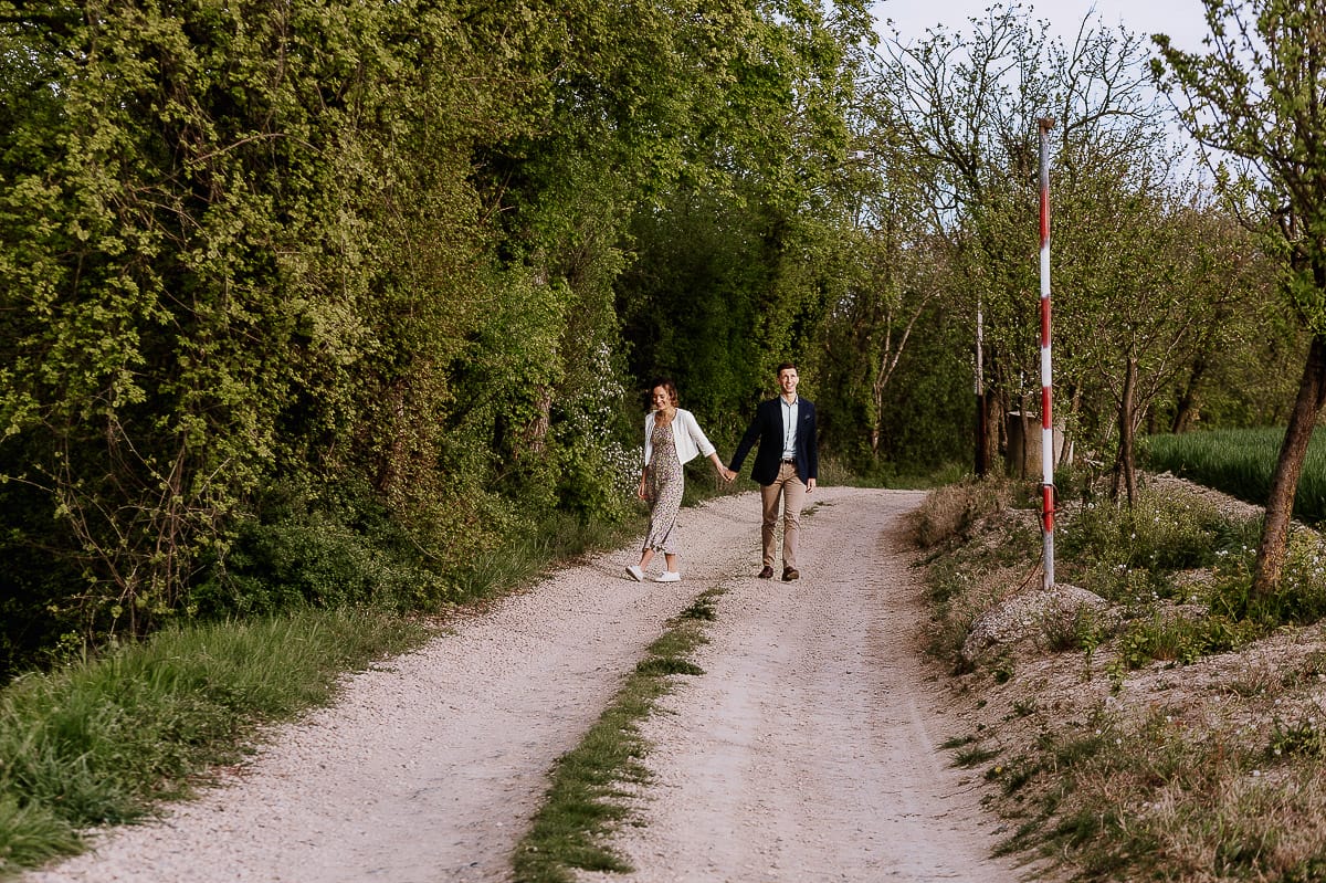 Prewedding primaverile in collina a Mombello di Torino di Federica e Mattia. La coppia cammina tenendosi per mano.