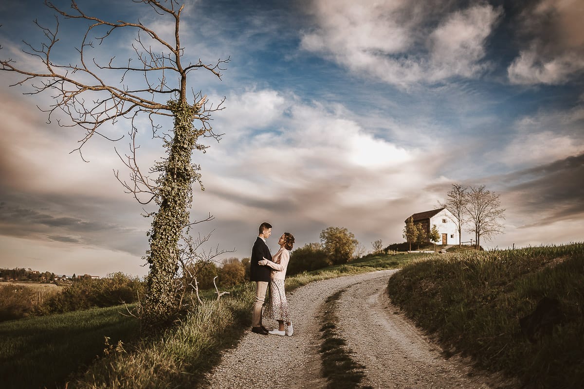 Prewedding primaverile in collina a Mombello di Torino di Federica e Mattia. Federica e Mattia si guardano. Dietro il cielo nuvoloso è bellissimo.