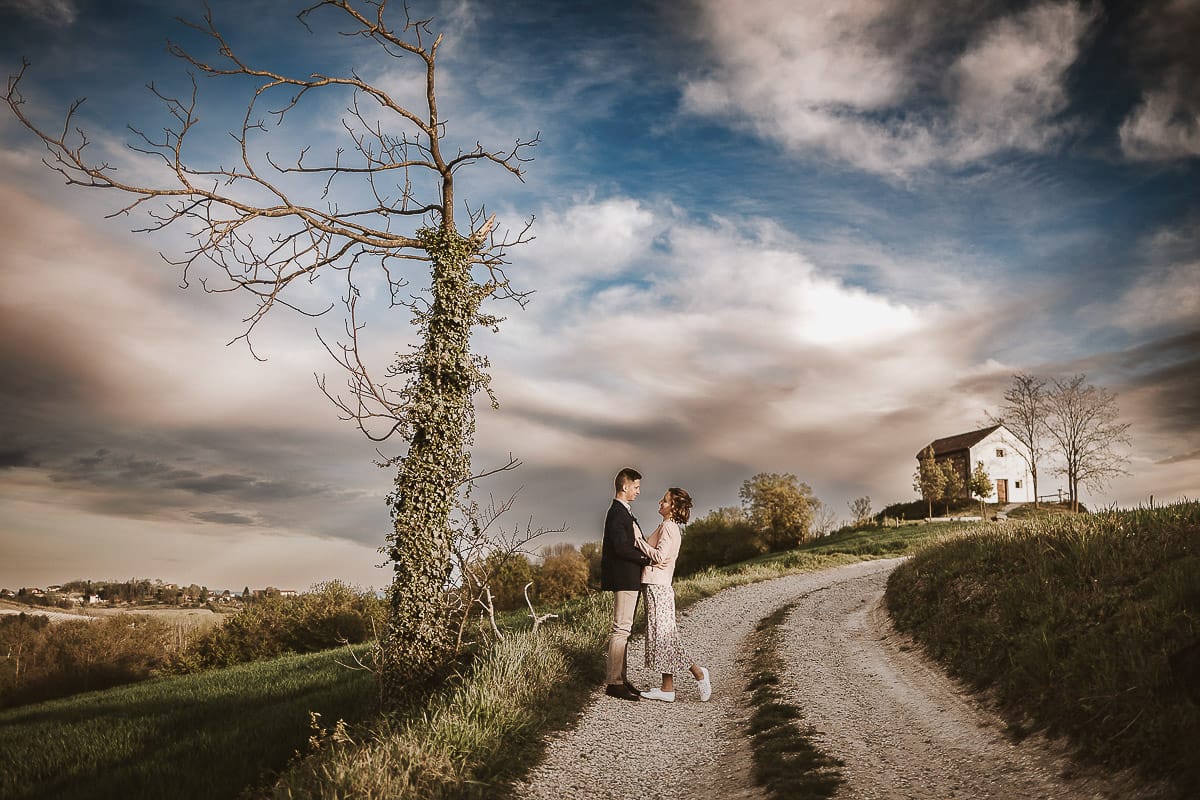 Prewedding primaverile in collina a Mombello di Torino di Federica e Mattia. Federica e Mattia si guardano. Dietro il cielo nuvoloso è bellissimo.