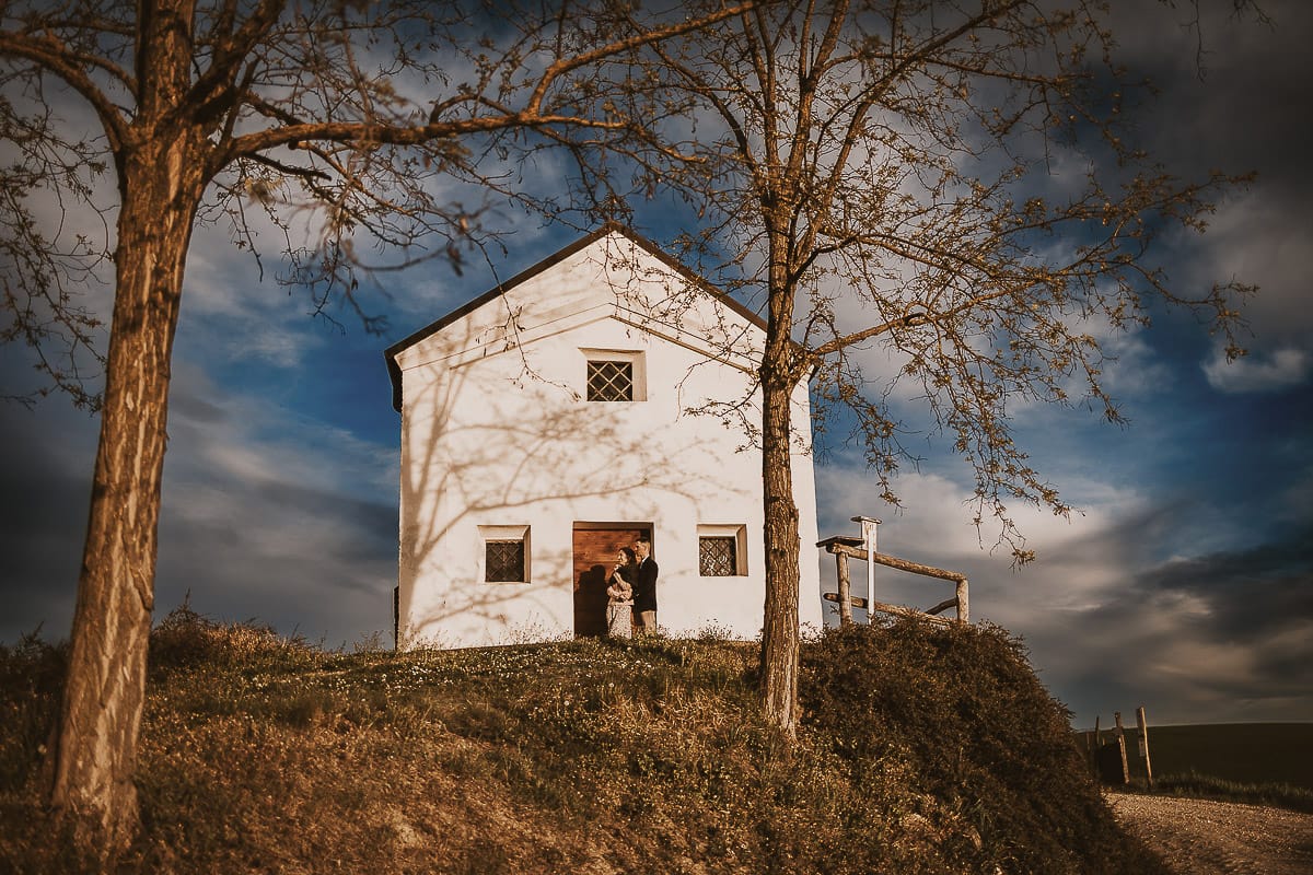 Prewedding primaverile in collina a Mombello di Torino di Federica e Mattia. Federica e Mattia di fronte alla chiesa di San Lorenzo. Foto ripresa dal basso