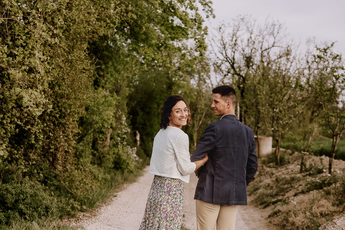 Prewedding primaverile in collina a Mombello di Torino di Federica e Mattia. La coppia cammina tenendosi a braccetto.