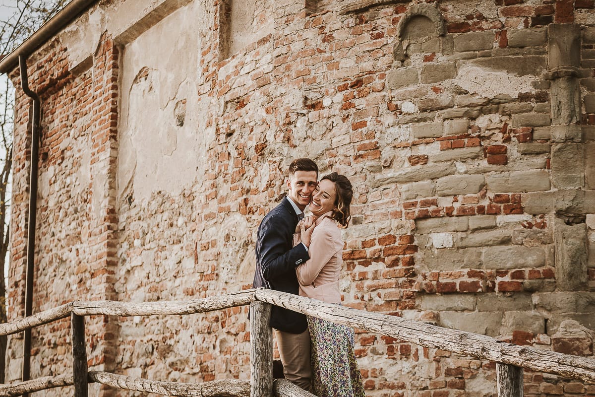 Prewedding primaverile in collina a Mombello di Torino di Federica e Mattia. Federica e Mattia di fronte alla chiesa di San Lorenzo. Mattia e Federica guancia a guancia.