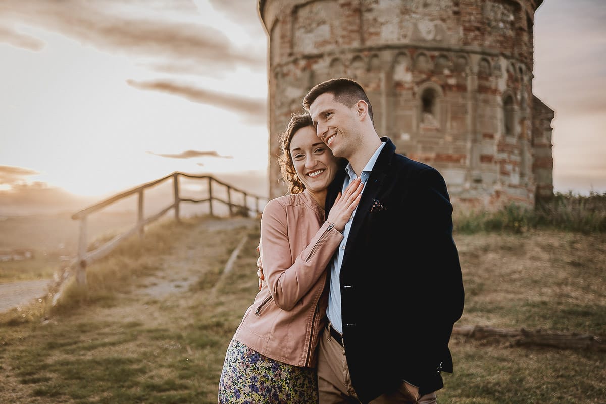 Prewedding primaverile in collina a Mombello di Torino di Federica e Mattia. Federica e Mattia guancia a guancia mentre il sole tramonta dietro di loro.