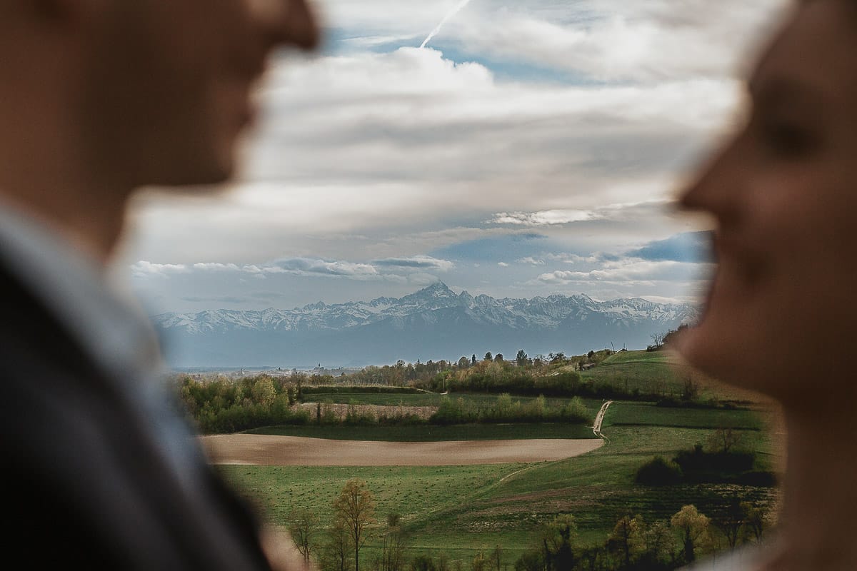 Prewedding primaverile in collina a Mombello di Torino di Federica e Mattia. Veduta del Monviso in lontananza tra la coppia fuori fuoco.