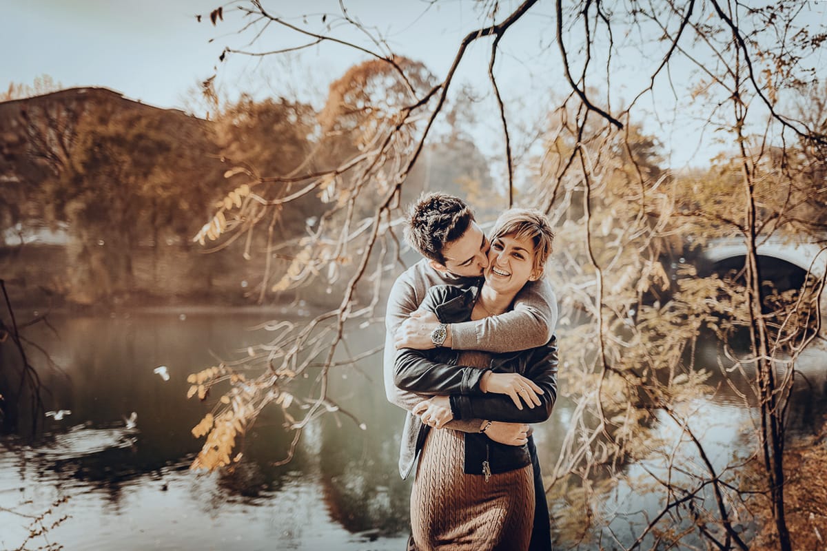 servizio fotografico prewedding da favola sul Lungo Po di Torino con il foliage autunnale. Cristina e Andrea si abbracciano davanti al ponte sul Po che si riflette nell'acqua