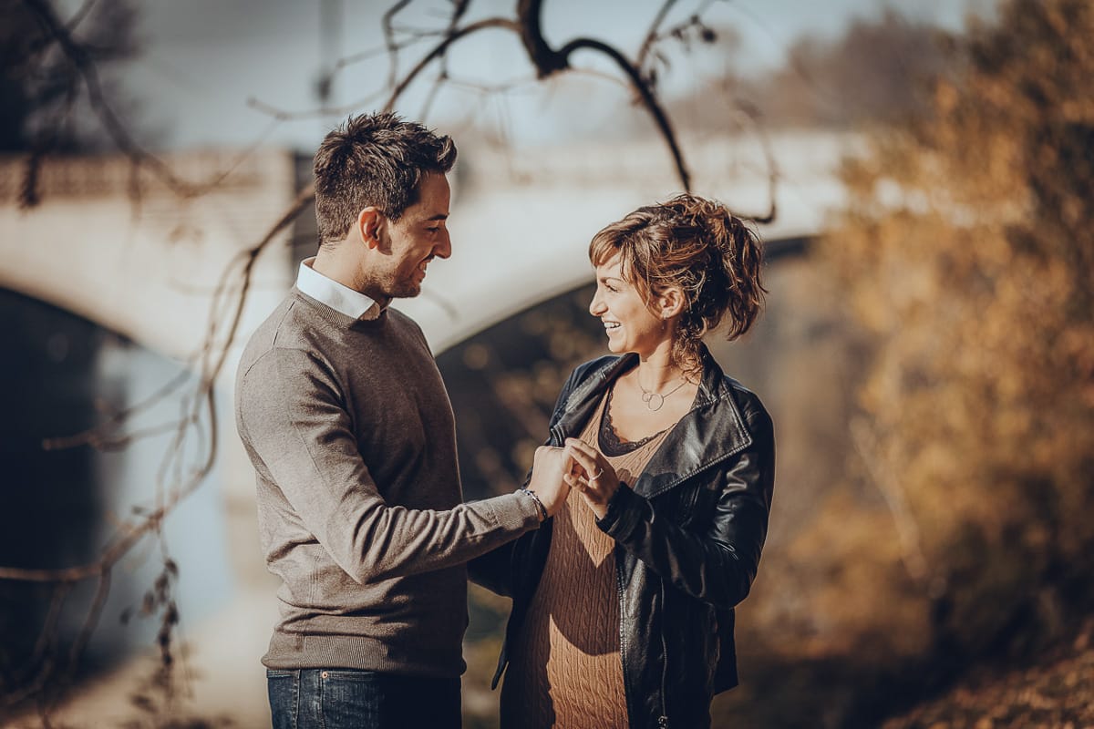 servizio fotografico prewedding da favola sul Lungo Po di Torino con il foliage autunnale. Cristina e Andrea si prendono per mano davanti al ponte sul Po che si riflette nell'acqua