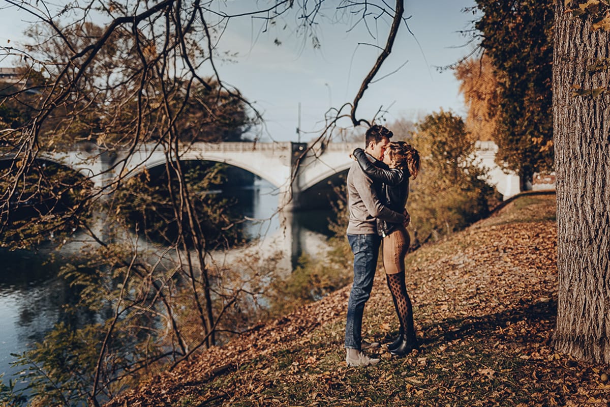 servizio fotografico prewedding da favola sul Lungo Po di Torino con il foliage autunnale. Cristina e Andrea si baciano davanti al ponte sul Po che si riflette nell'acqua