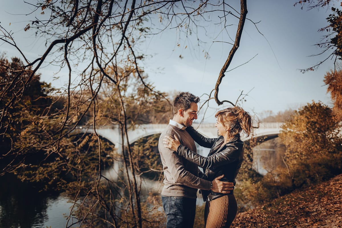 servizio fotografico prewedding da favola sul Lungo Po di Torinocon il foliage autunnale. Cristina e Andrea si abbracciano davanti al ponte sul Po che si riflette nell'acqua
