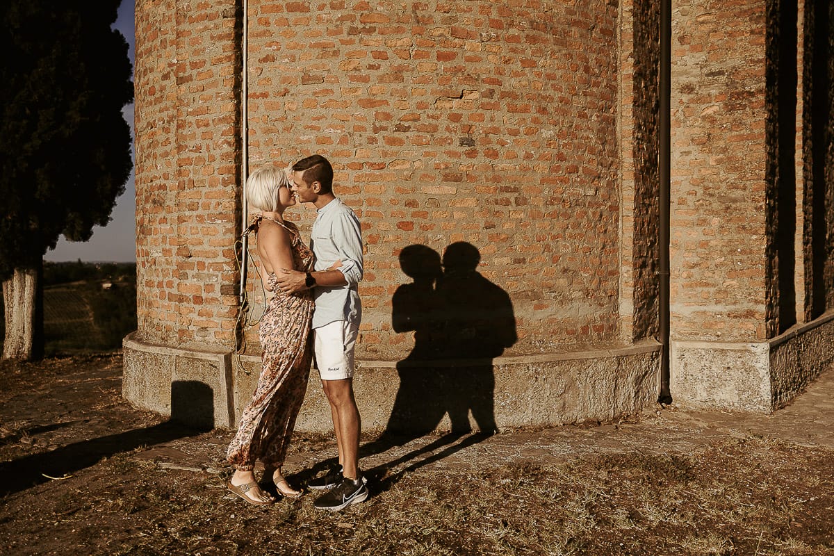 Prewedding da sogno a Nizza Monferrato intorno alla chiesa della Madonna della Neve. Matteo e Fiammetta si guardano intensamente. la loro ombra è proiettata sul muro della chiesa