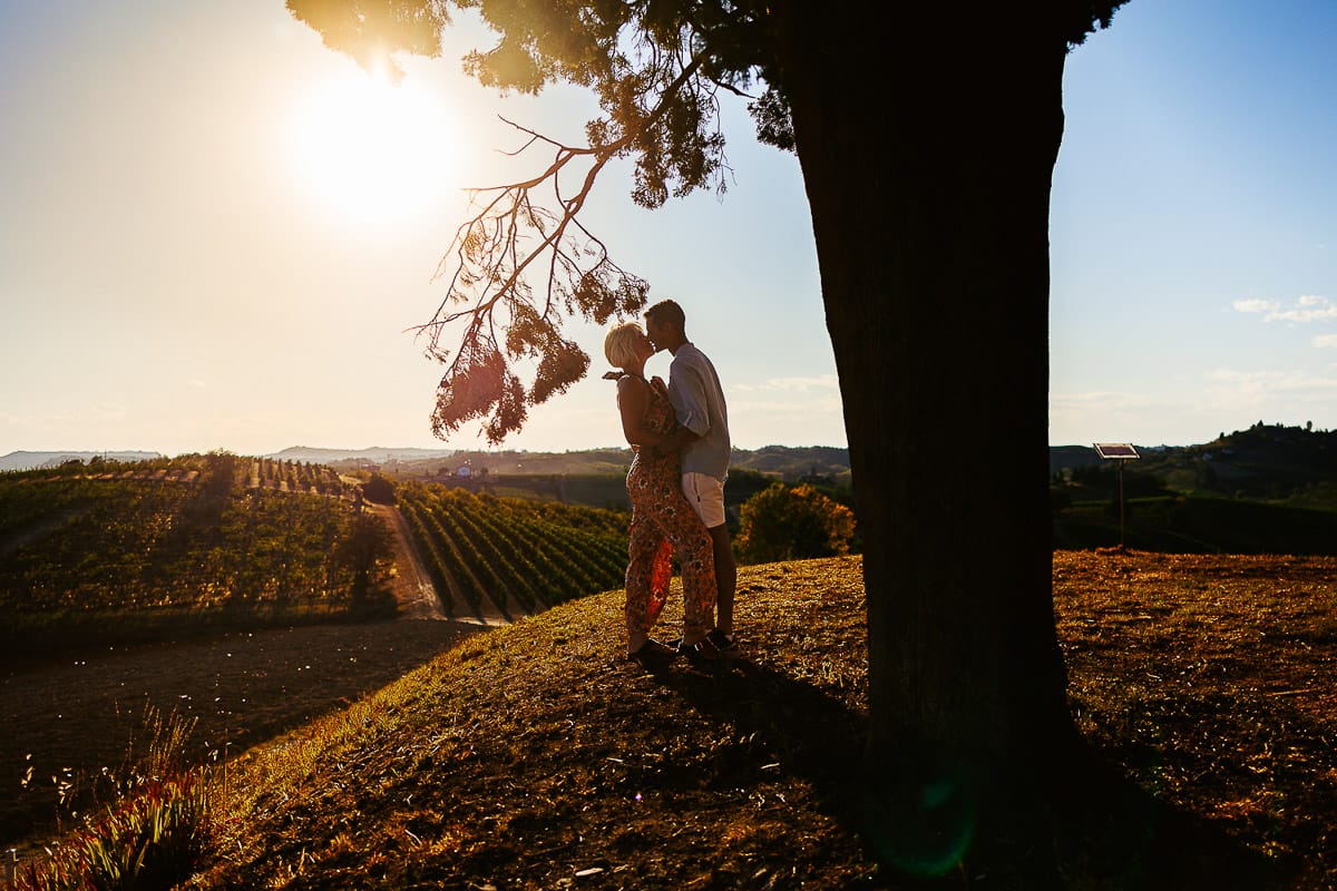 Prewedding da sogno a Nizza Monferrato intorno alla chiesa della Madonna della Neve. Matteo e Fiammetta si guardano intensamente in controluce, con il sole che sta per tramontare dietro i vigneti.