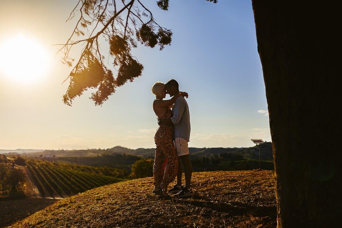 Prewedding da sogno a Nizza Monferrato intorno alla chiesa della Madonna della Neve. Matteo e Fiammetta si guardano intensamente in controluce, con il sole che sta per tramontare dietro i vigneti.