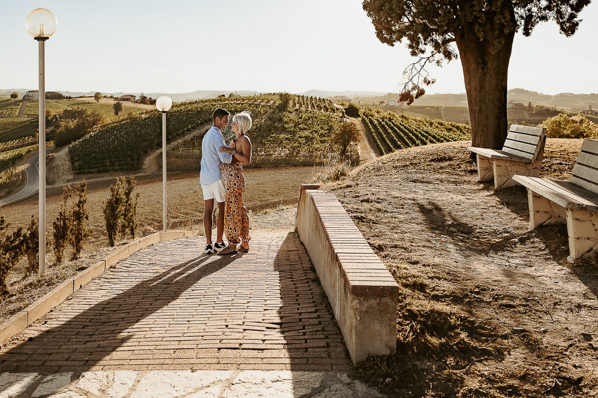 Prewedding da sogno a Nizza Monferrato intorno alla chiesa della Madonna della Neve. Matteo e Fiammetta camminano lungo il vialetto verso i vigneti.