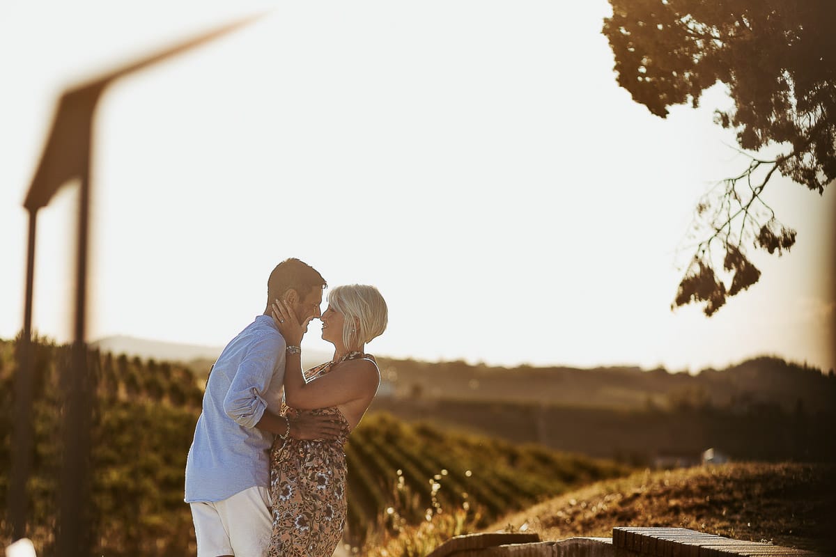 Prewedding da sogno a Nizza Monferrato intorno alla chiesa della Madonna della Neve. Matteo e Fiammetta camminano lungo il vialetto verso i vigneti. Ritratto in controluce