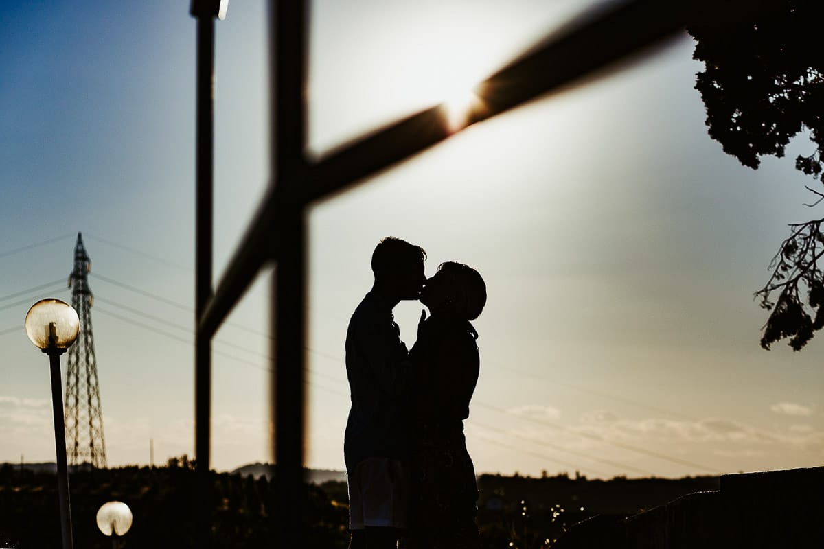 Prewedding da sogno a Nizza Monferrato intorno alla chiesa della Madonna della Neve. Matteo e Fiammetta camminano lungo il vialetto verso i vigneti. ritratto in controluce, silhouette
