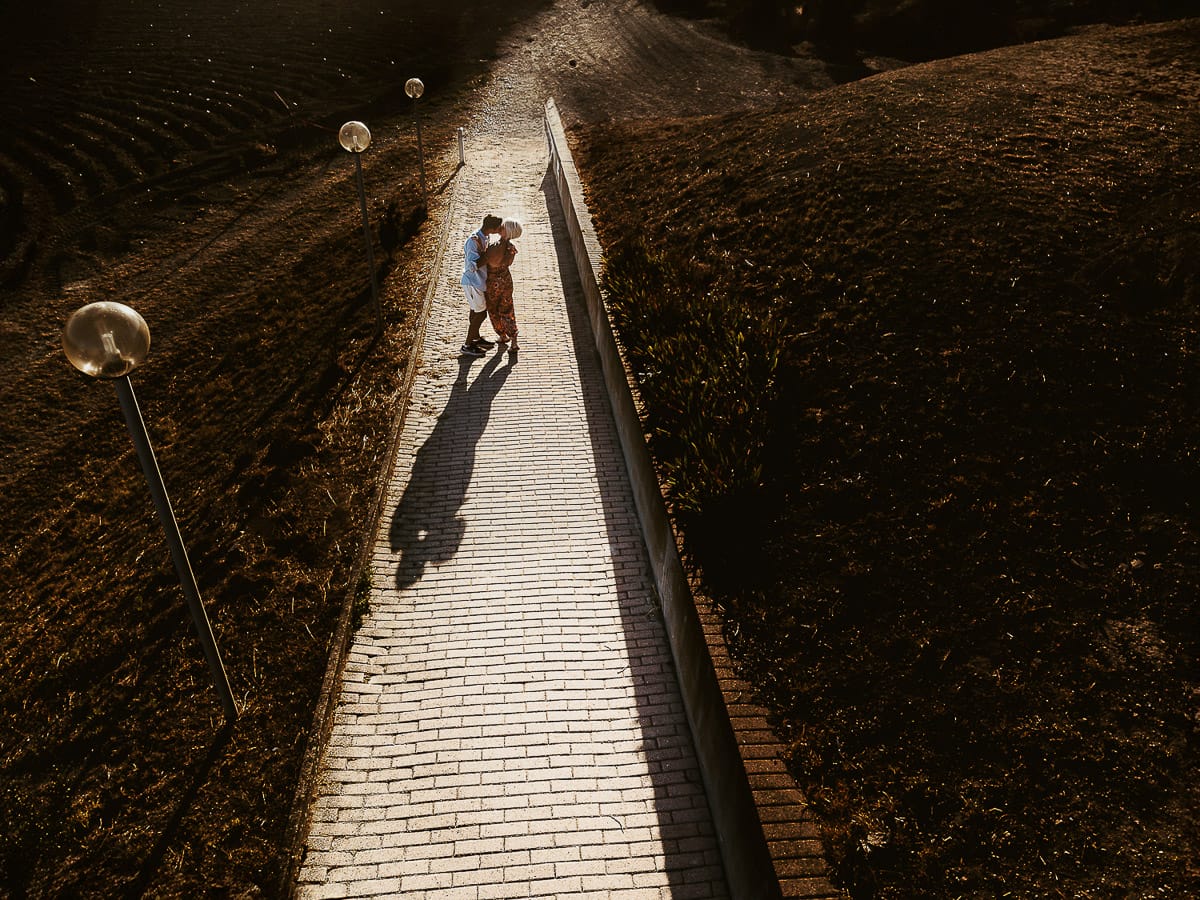 Prewedding da sogno a Nizza Monferrato intorno alla chiesa della Madonna della Neve. Matteo e Fiammetta camminano lungo il vialetto verso i vigneti. foto aerea dal drone