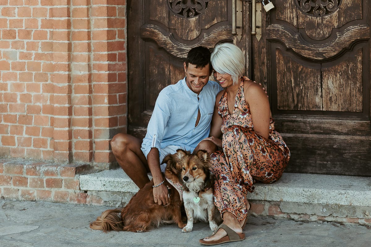 Prewedding da sogno a Nizza Monferrato intorno alla chiesa della Madonna della Neve. Fiammetta e Matteo seduti sul gradino del portone della chiesa con i loro volpini Megan e Harry