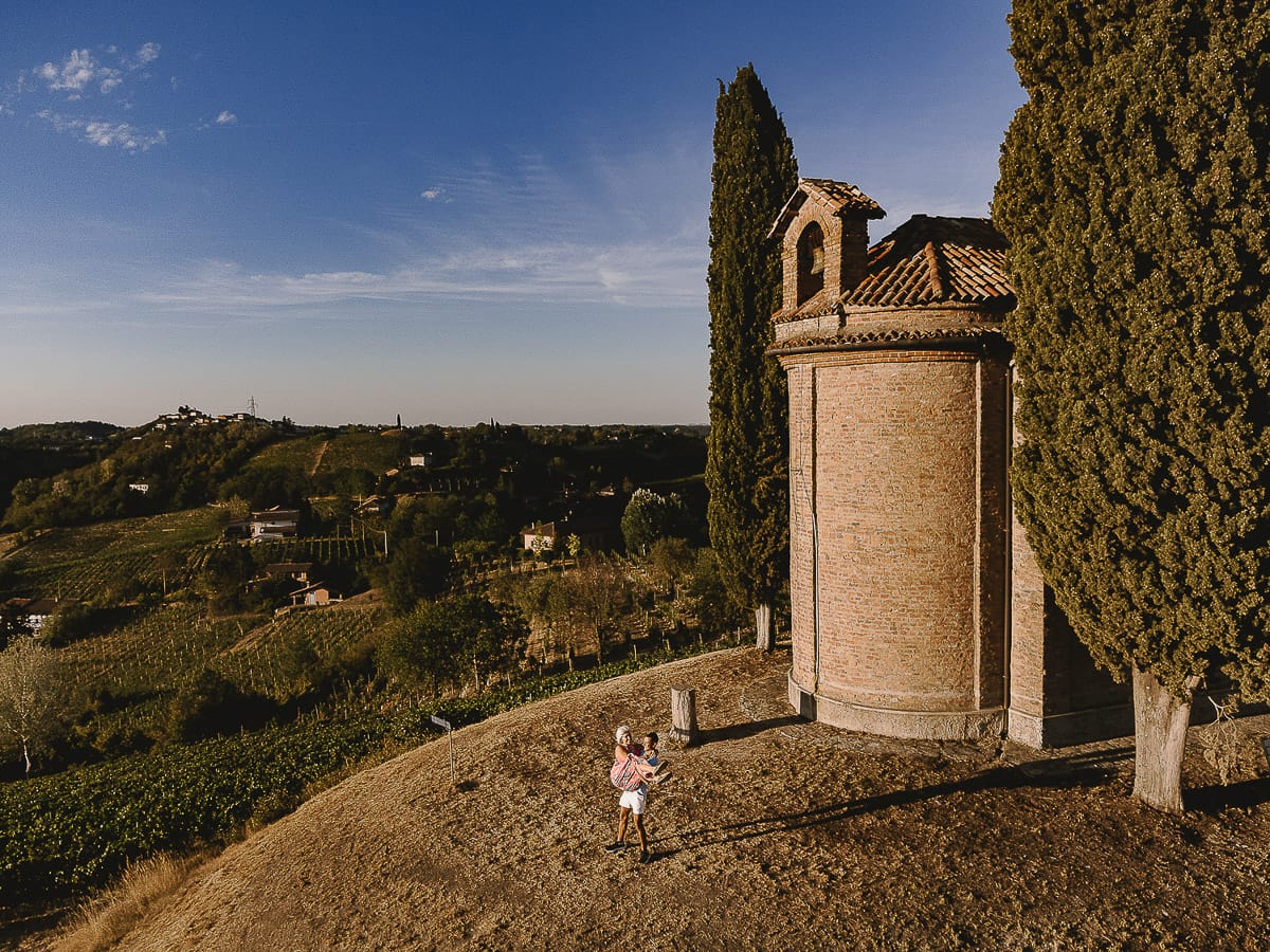Prewedding da sogno a Nizza Monferrato intorno alla chiesa della Madonna della Neve. Matteo abbraccia Fiammetta. Foto ripresa dal basso. Foto dal drone