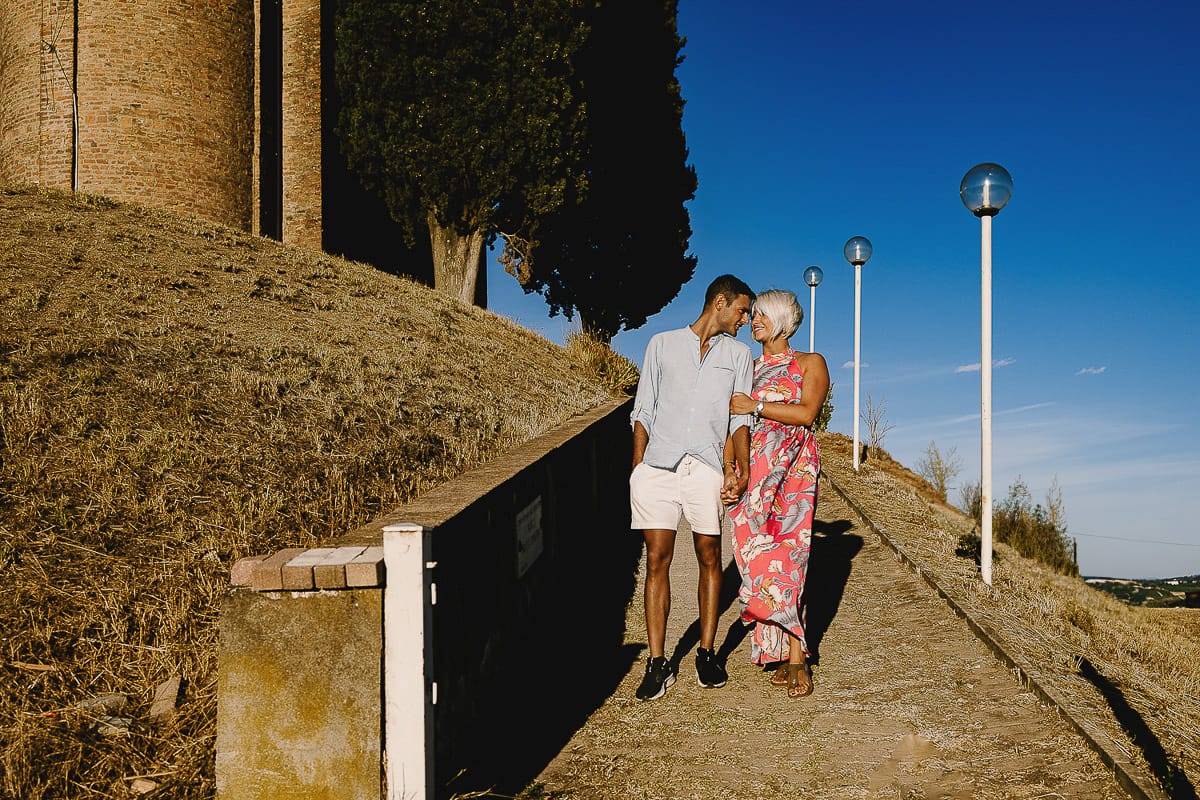 Prewedding da sogno a Nizza Monferrato intorno alla chiesa della Madonna della Neve. Fiammetta e matteo scendono dal vialetto verso il vigneto.