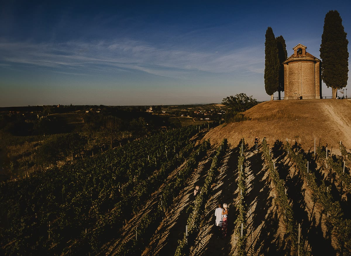 Prewedding da sogno a Nizza Monferrato intorno alla chiesa della Madonna della Neve. Fiammetta e Matteo nel vigneto. Foto aerea dal drone con il panorama della chiesa.
