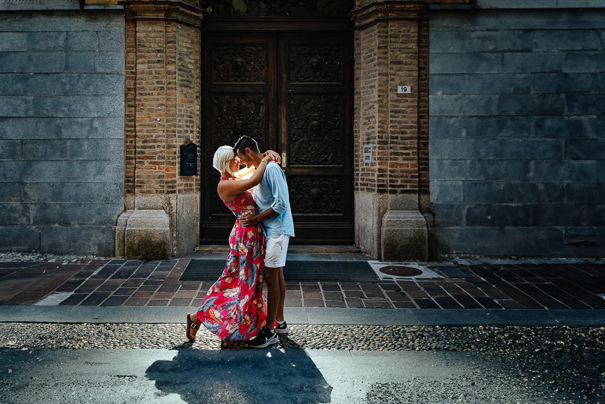Prewedding da sogno a Nizza Monferrato nel centro storico. Fiammetta e Matteo davanti al bellissimo portone scolpito di un palazzo. storico. Flash off camera dietro la coppia