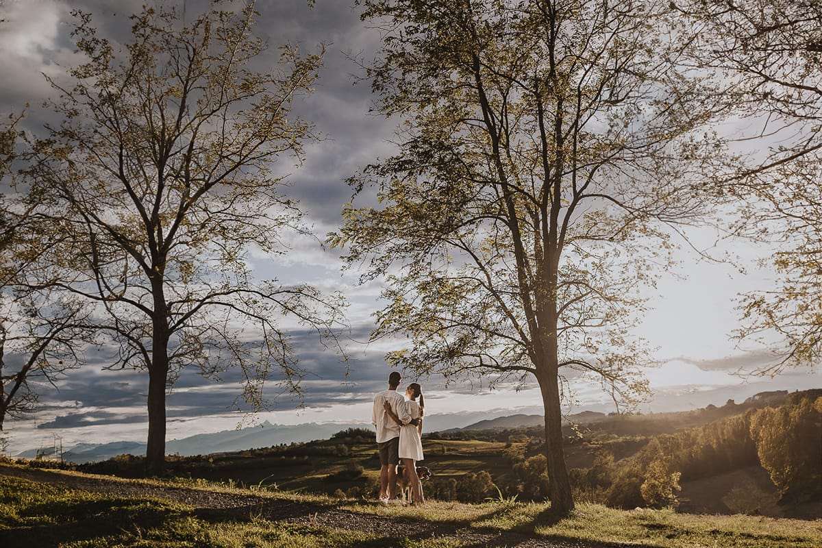 Prewedding spontaneo e poetico nel Monferrato a Mombello di Torino. Federica e Riccardo abbracciati guardano il meraviglioso panorma delle colline.