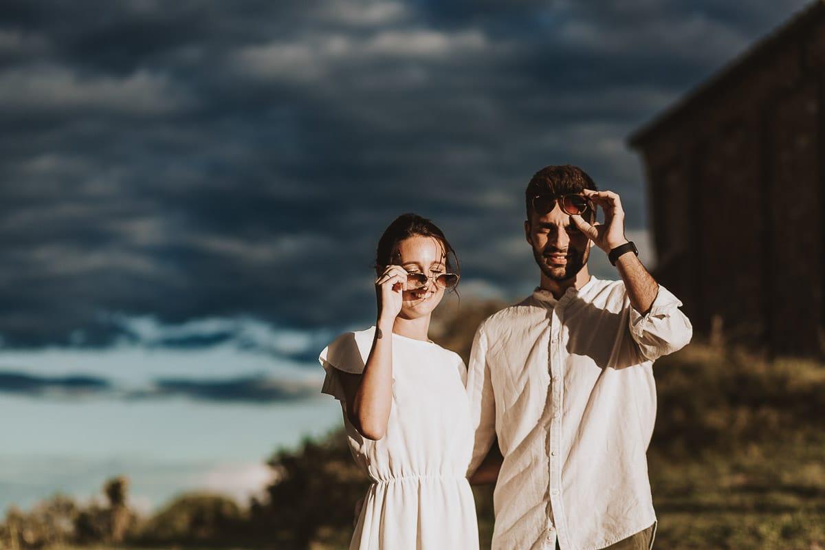 Prewedding spontaneo e poetico nel Monferrato a Mombello di Torino. Federica e Riccardo camminano abbracciati togliendosi gli occhiali da sole