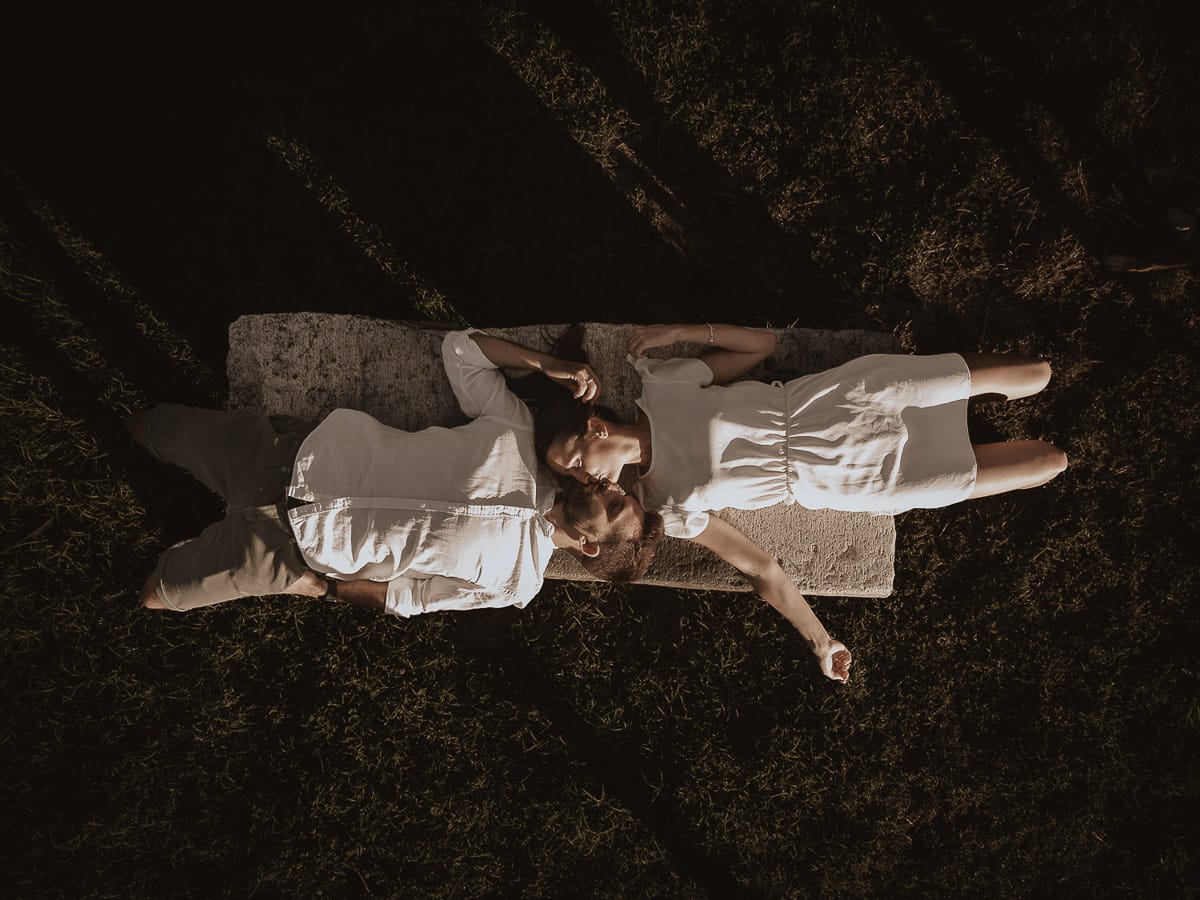 Prewedding spontaneo e poetico nel Monferrato a Mombello di Torino. Federica e Riccardo si baciano sdraiati su di una panchina di pietra. Foto dal drone.